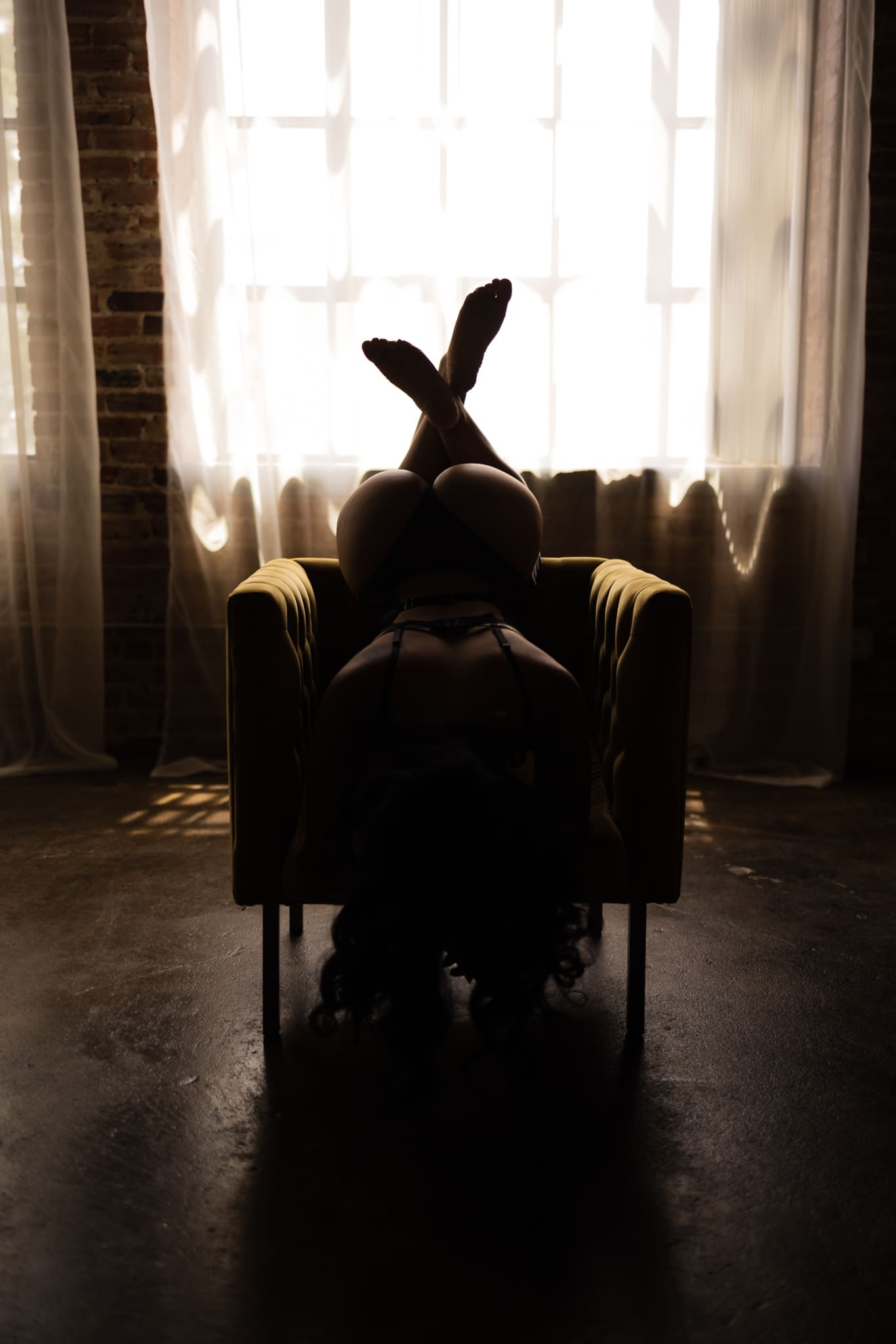 Woman demonstrating a challenging boudoir pose during a professional photography session.